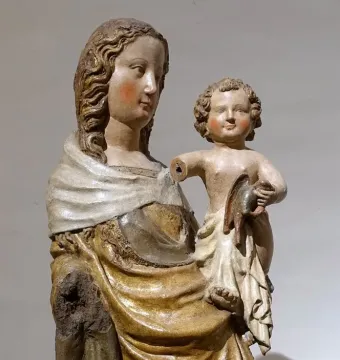 Friesentor Madonna, a polychrome sculpture of a woman holding a child with rosy cheeks and flowing hair.
