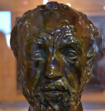 Bronze bust of Man with the Broken Nose with a wrinkled brow, deep-set eyes, and a prominent nose.