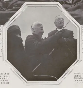 Two men pull a cord to unveil the Bartolomé Mitre Monument as onlookers watch.