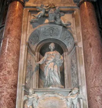 Tomb of Countess Matilda of Tuscany with a marble statue in an arched niche, surrounded by reliefs and reddish-brown columns.