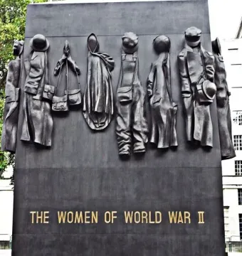 The Women of World War II monument with eleven relief figures and gold lettering.