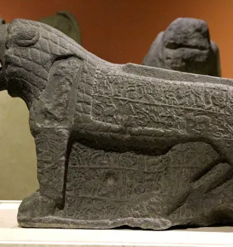 Maraş lion stone sculpture with an open mouth and carved inscriptions on its sides and legs.