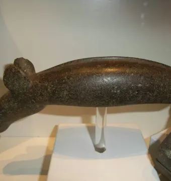 The Alunda Moose stone sculpture displayed on a clear stand with a white base.