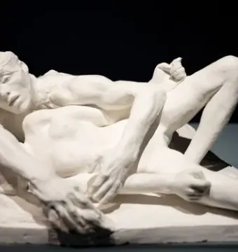 Auguste Rodin\'s Avarice and Lust showing two nude figures in a tight embrace on a base.