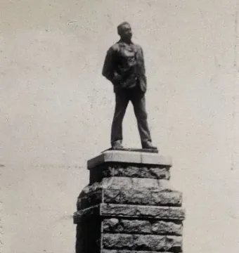 Statue of Cecil Rhodes standing on a tall stone pedestal.