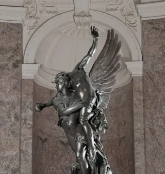 Gloria Victis bronze sculpture showing a winged figure supporting a dying warrior against a marbled wall.