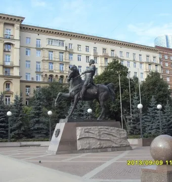 Pyotr Bagration Monument, a bronze equestrian statue on a stone pedestal in a paved plaza with trees and city buildings behind it.