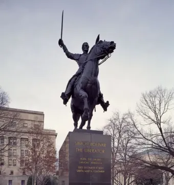 Simón Bolívar equestrian statue of a man in military uniform raising a sword while mounted on a rearing horse.