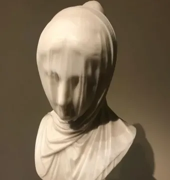 The Veiled Nun marble bust with a delicate veil covering the face and draping over the shoulders.