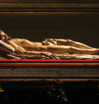 Cristo Yacente, a recumbent sculpture of Christ lying on a raised platform with visible wounds.
