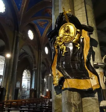 Memorial to Maria Raggi mounted on a marble pillar inside a church interior with painted ceilings and pews.