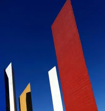 Torres de Satélite with five brightly colored geometric towers against a blue sky.