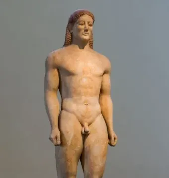 Kroisos Kouros, a nude ancient male statue with braided hair and a slight smile.