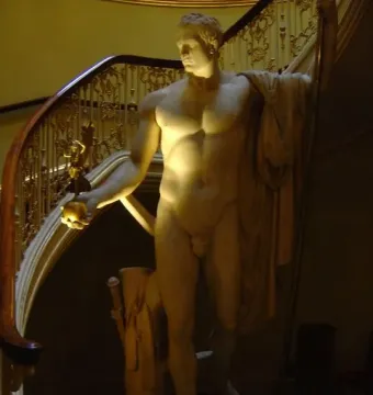Napoleon as Mars the Peacemaker marble statue of a nude male figure holding a staff and orb beside a staircase