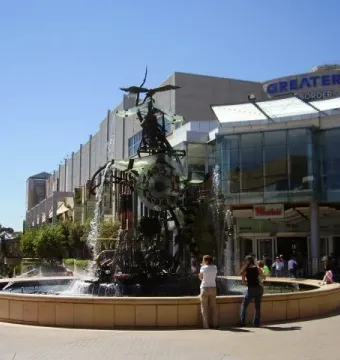 Hornsby Water Clock fountain sculpture with gears, pipes, and cascading water in a plaza