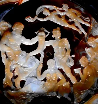 The Tazza Farnese carved gem shows a detailed relief scene with a bearded figure holding a horn among draped and partially nude figures.