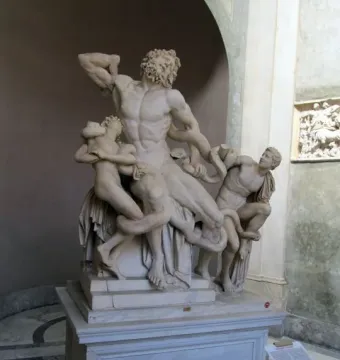 Laocoön and His Sons marble sculpture with a muscular male figure and two younger figures entwined by serpents in an arched gallery