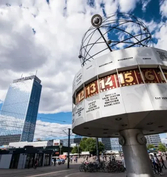The World Clock in Alexanderplatz, a cylindrical public clock with city names and times beneath a globe structure.