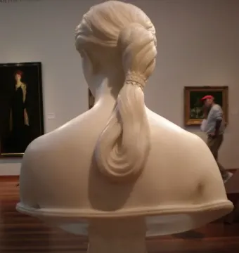 Rear view of California by Hiram Powers, showing the marble bust from behind with a detailed braided ponytail.