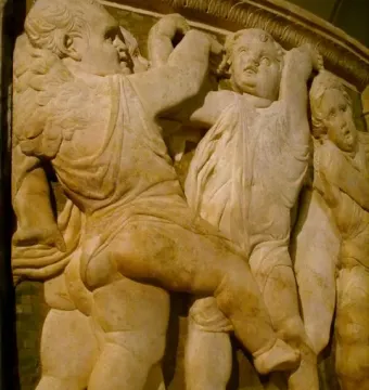 Close-up of Donatello’s Pulpit of Prato Cathedral showing winged putti in a marble relief.