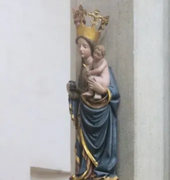 Inkpot Madonna, a colorful statue of the Virgin Mary holding the Christ Child, with an inkpot in her hand.