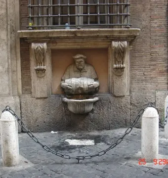 The Porter fountain carved into a wall, with a man holding a barrel as water pours into a basin.