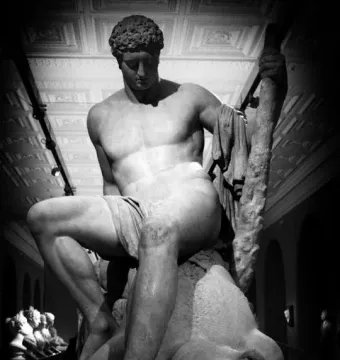 Theseus and the Minotaur marble sculpture showing a man seated on the defeated minotaur\'s body.
