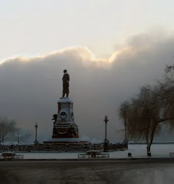 Monument of Alexander III standing on an ornate pedestal in a snowy winter landscape