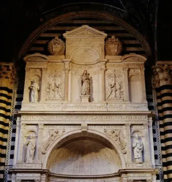 Piccolomini Altarpiece with multiple marble figures in niches and relief panels inside Siena Cathedral.
