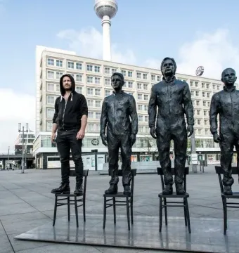 Anything to Say? sculpture figures standing on chairs in Berlin, with the TV Tower in the background.