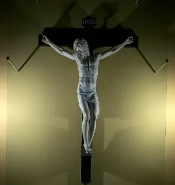 Benvenuto Cellini crucifix in white marble, showing Christ on a dark cross with INRI at the top.