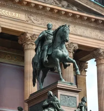 Frederick William IV equestrian statue on a granite pedestal with allegorical bronze figures at the base.