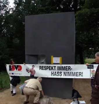 The Memorial to Homosexuals Persecuted Under Nazism with a protest banner reading \