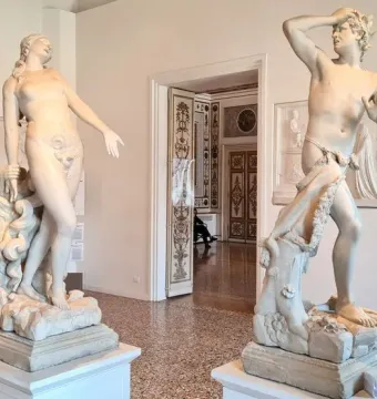 Orfeo y Eurídice marble statues displayed on pedestals in a museum gallery