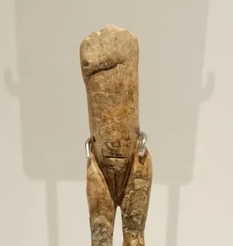 Immodest Venus ivory female figurine on a dark stand with silver-toned clips