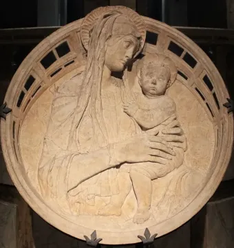 Madonna del Perdono relief showing the Madonna holding the child beneath a decorated arch