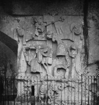 Externsteine Relief carved into a rocky cliff face, showing draped figures around a central cross.