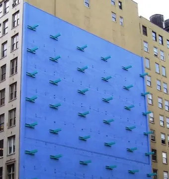 The Wall by Forrest Myers, showing a bright blue wall with teal angled forms arranged in a grid.