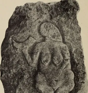 Venus of Laussel, a stone relief of a nude female figure holding a curved horn overhead.