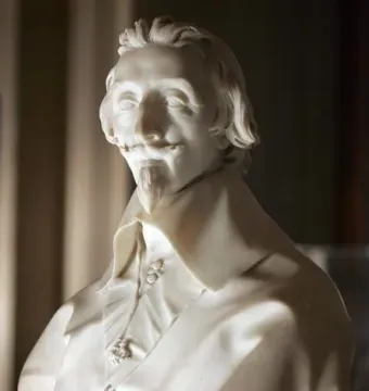 White marble bust of Cardinal Richelieu with wavy hair, mustache, and goatee.