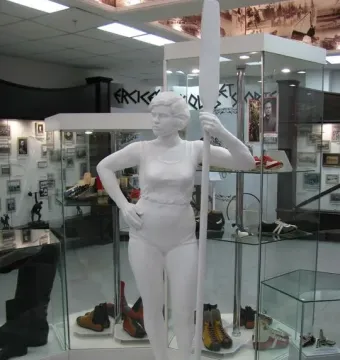 White Girl with an Oar sculpture of a woman holding a tall oar beside display cases in a museum exhibit
