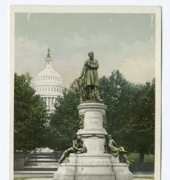 James A. Garfield Monument with a bronze statue on a tiered stone pedestal, surrounded by smaller bronze figures in a park with the U.S. Capitol dome in the background.