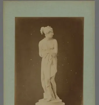 Venus Italica marble statue standing on a round pedestal, partially draped and facing right.