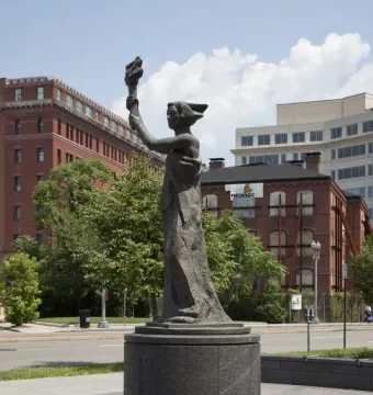 Victims of Communism Memorial bronze statue of a draped female figure holding a torch on a dark pedestal.