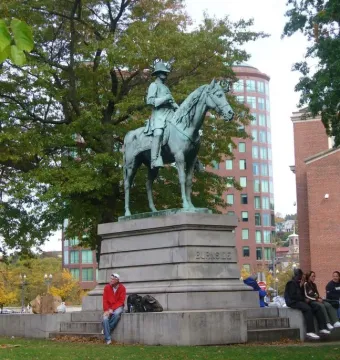 Ambrose Burnside Monument showing an equestrian bronze statue on a stone base inscribed Burnside, with people seated on the steps nearby.