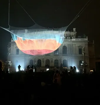 Janet Echelman’s 1.26 suspended above a crowd at night, with a lit neoclassical building in the background.