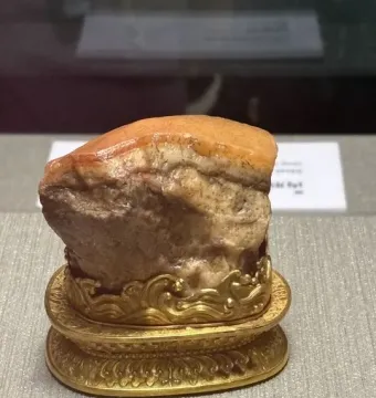 Meat-Shaped Stone displayed on an ornate golden stand
