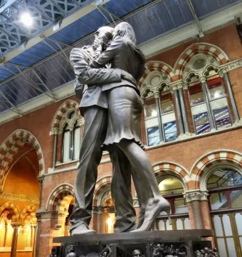 The Meeting Place bronze sculpture of a couple embracing inside St Pancras International Station.