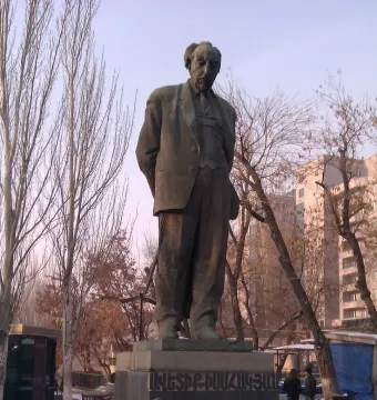 Bronze statue of Avetik Isahakyan standing on a stone pedestal in Yerevan.