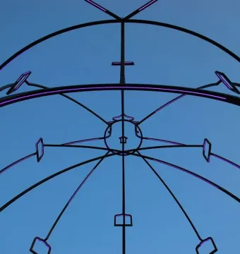 Memoria Urbana’s black metal framework lit with purple lights against a blue sky.